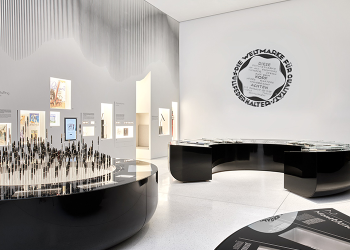 Montblanc Haus, Hamburg. Exhibition displays Corian<sup>®</sup> Deep Nocturne with mirror polished finish and embedded multimedia screen. Pens are planted like trees in a backlit Corian<sup>®</sup> Glacier Ice socle. Wall niche carved in a Glacier Ice Corian<sup>®</sup> wall. Design by Projectiles; fabrication by Crea Design; images by Daniel Schafer, all right reserved.